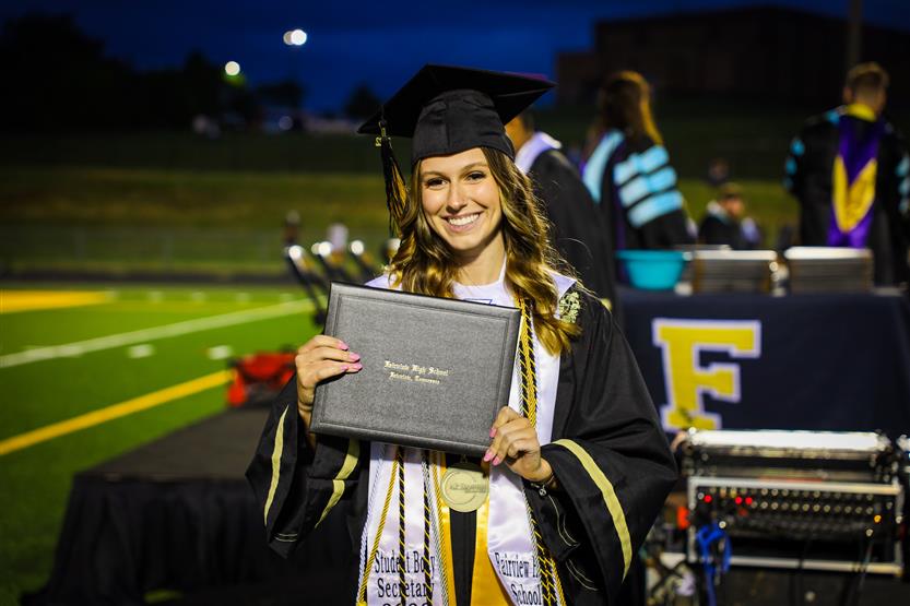Students graduate on a football field